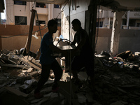 Palestinians are inspecting the rubble following overnight Israeli bombardment which is hitting the Abu Nada family home at the Nuseirat ref...