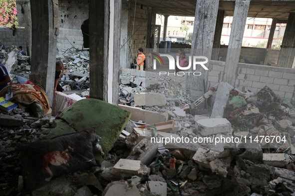 Palestinians are inspecting the rubble following overnight Israeli bombardment which is hitting the Abu Nada family home at the Nuseirat ref...