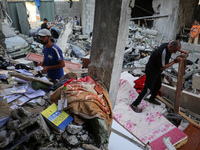 Palestinians are inspecting the rubble following overnight Israeli bombardment which is hitting the Abu Nada family home at the Nuseirat ref...