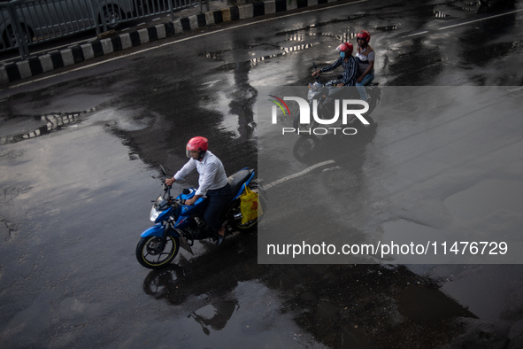 Bike riders are riding their motorcycles after rain during rush hour in Dhaka, Bangladesh, on August 13, 2024. 