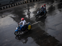 Bike riders are riding their motorcycles after rain during rush hour in Dhaka, Bangladesh, on August 13, 2024. (