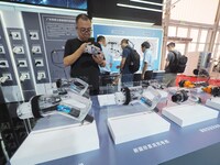 Visitors are viewing a ''charging gun'' at the 2024 Beijing International Charging Pile and Converter Exhibition in Beijing, China, on Augus...