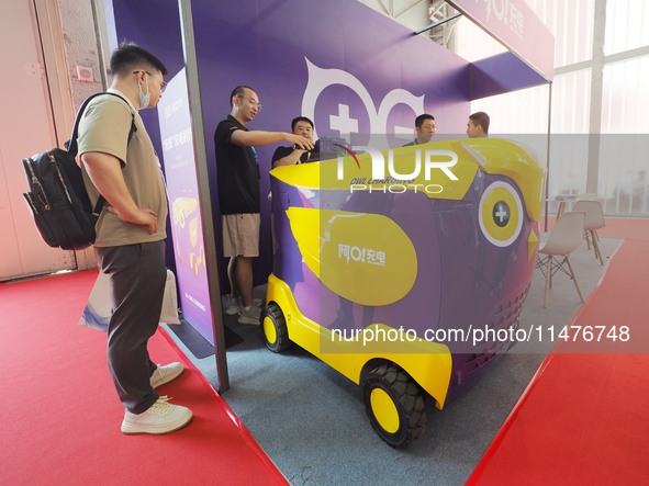 Visitors are visiting a ''mobile charging vehicle'' at the 2024 Beijing International Charging Pile and Power Station Exhibition in Beijing,...