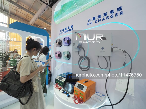 Visitors are visiting a charging pile at the 2024 Beijing International Charging Pile and Converter Exhibition in Beijing, China, on August...