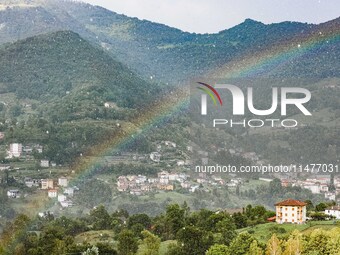 A general view of a rainbow is appearing in the mountains in Bergamo, Italy, on August 13, 2024 (