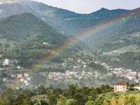 A general view of a rainbow is appearing in the mountains in Bergamo, Italy, on August 13, 2024 (