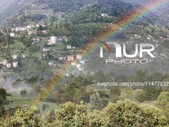 A general view of a rainbow is appearing in the mountains in Bergamo, Italy, on August 13, 2024 (