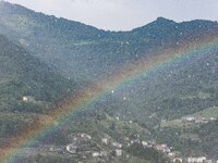 A general view of a rainbow is appearing in the mountains in Bergamo, Italy, on August 13, 2024 (