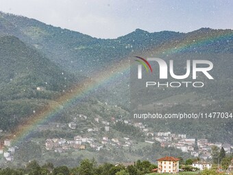 A general view of a rainbow is appearing in the mountains in Bergamo, Italy, on August 13, 2024 (