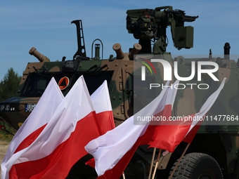 Polish national flags and Light Armored Reconnaissance Carriers KLESZCZ are seen during a ceremony of signing a contract to buy light armour...