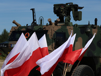 Polish national flags and Light Armored Reconnaissance Carriers KLESZCZ are seen during a ceremony of signing a contract to buy light armour...