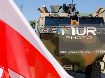 Polish national flags and Light Armored Reconnaissance Carriers KLESZCZ are seen during a ceremony of signing a contract to buy light armour...