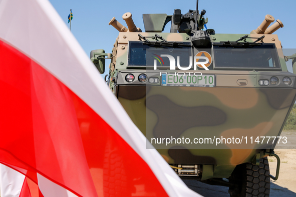 Polish national flags and Light Armored Reconnaissance Carriers KLESZCZ are seen during a ceremony of signing a contract to buy light armour...