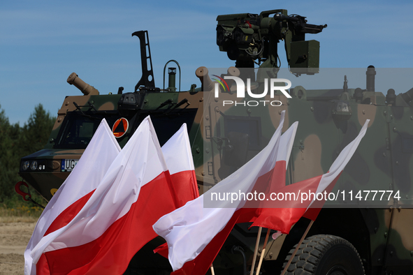 Polish national flags and Light Armored Reconnaissance Carriers KLESZCZ are seen during a ceremony of signing a contract to buy light armour...