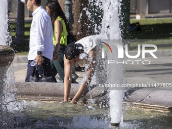 Tourist, visitors and locals are walking past Syntagma Square with the famous fountain during a heatwave in Athens with the high temperature...