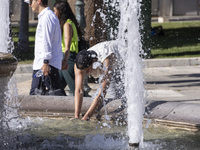 Tourist, visitors and locals are walking past Syntagma Square with the famous fountain during a heatwave in Athens with the high temperature...