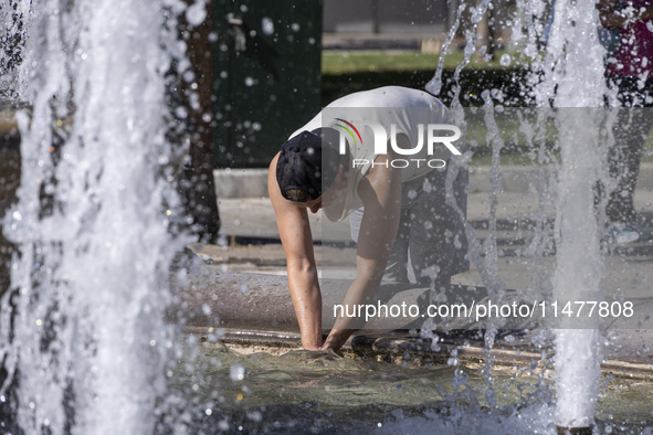 Tourist, visitors and locals are walking past Syntagma Square with the famous fountain during a heatwave in Athens with the high temperature...