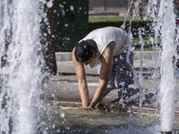 Tourist, visitors and locals are walking past Syntagma Square with the famous fountain during a heatwave in Athens with the high temperature...