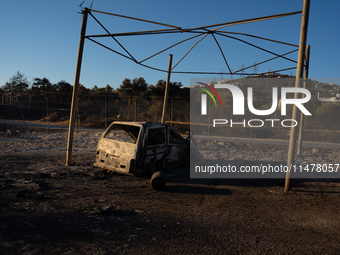 A destroyed car is sitting in a lumber warehouse in the Vrilissia area, due to the fire that broke out in Athens, Greece, on August 11, 2024...