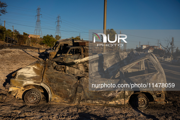 A destroyed car is sitting in a lumber warehouse in the Vrilissia area, due to the fire that broke out in Athens, Greece, on August 11, 2024...