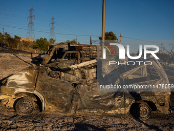 A destroyed car is sitting in a lumber warehouse in the Vrilissia area, due to the fire that broke out in Athens, Greece, on August 11, 2024...