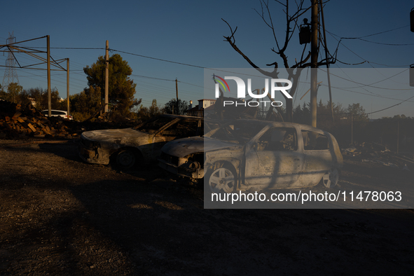 A destroyed car is sitting in a lumber warehouse in the Vrilissia area, due to the fire that broke out in Athens, Greece, on August 11, 2024...