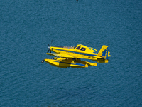 A firefighting plane is collecting water from Marathon Lake to extinguish flare-ups in Marathon, Greece, on August 14, 2024 (