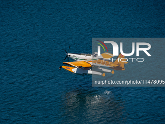 A firefighting plane from Turkey is collecting water from Marathon Lake to combat the flare-ups in Marathon, Greece, on August 14, 2024 (