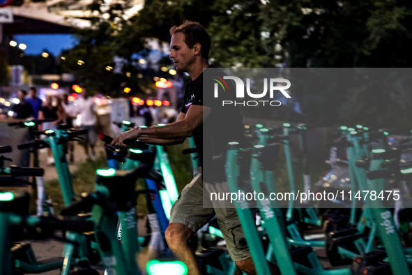 A man collects Bolt electric commercial scooter available for public commute in central Warsaw, the capital of Poland on August 14, 2024. 