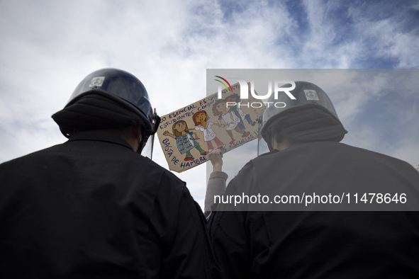 The teacher is showing a poster in defense of education to the Federal Police  during a protest of Education Workers' Union in Buenos Aires,...