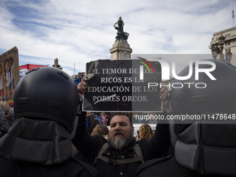 The teacher is showing a poster in defense of education to the Federal Police  during a protest of Education Workers' Union in Buenos Aires,...