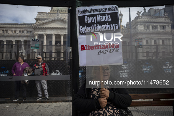 A teacher is holding a banner and asking the teachers union for a strike and fight plan  during a protest of Education Workers' Union in Bue...