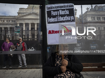 A teacher is holding a banner and asking the teachers union for a strike and fight plan  during a protest of Education Workers' Union in Bue...