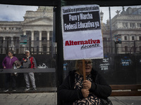 A teacher is holding a banner and asking the teachers union for a strike and fight plan  during a protest of Education Workers' Union in Bue...