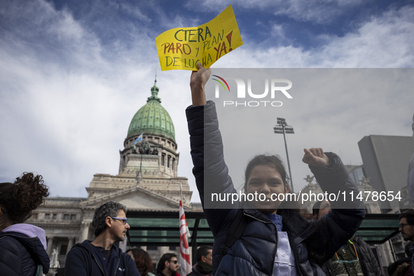 A teacher is holding a banner and asking the teachers union for a strike and fight plan  during a protest of Education Workers' Union in Bue...