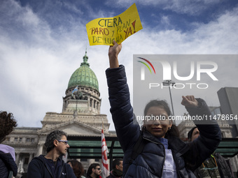 A teacher is holding a banner and asking the teachers union for a strike and fight plan  during a protest of Education Workers' Union in Bue...