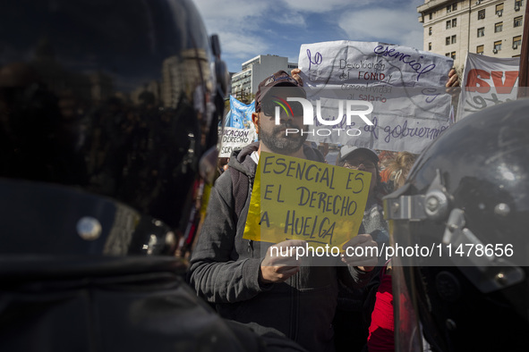 The teacher is showing a poster in defense of education to the Federal Police  during a protest of Education Workers' Union in Buenos Aires,...