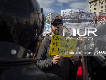 The teacher is showing a poster in defense of education to the Federal Police  during a protest of Education Workers' Union in Buenos Aires,...