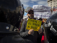 The teacher is showing a poster in defense of education to the Federal Police  during a protest of Education Workers' Union in Buenos Aires,...