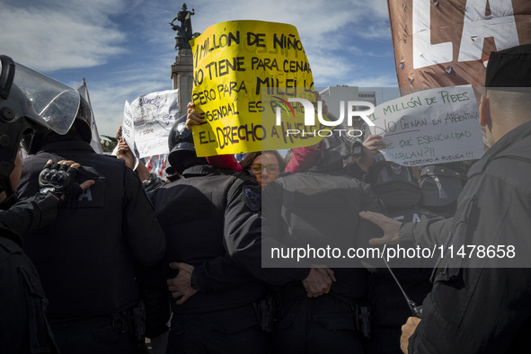 The teacher is showing a poster in defense of education to the Federal Police during a protest of Education Workers' Union in Buenos Aires,...