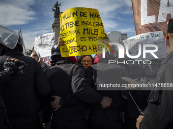 The teacher is showing a poster in defense of education to the Federal Police during a protest of Education Workers' Union in Buenos Aires,...