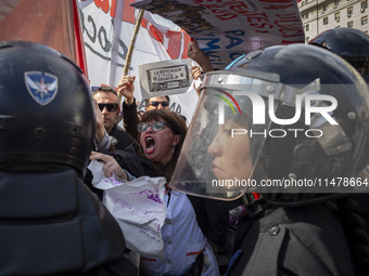 The teacher is showing a poster in defense of education to the Federal Police during a protest of Education Workers' Union in Buenos Aires,...