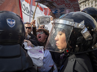 The teacher is showing a poster in defense of education to the Federal Police during a protest of Education Workers' Union in Buenos Aires,...