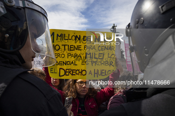 The teacher is showing a poster in defense of education to the Federal Police during a protest of Education Workers' Union in Buenos Aires,...