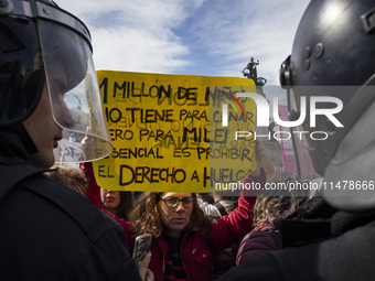 The teacher is showing a poster in defense of education to the Federal Police during a protest of Education Workers' Union in Buenos Aires,...