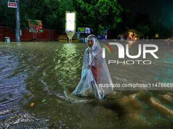 Locals are moving through the waterlogged road at Narayan Singh Circle following heavy monsoon rains, in Jaipur, Rajasthan, India, on August...