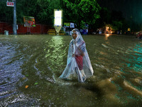 Locals are moving through the waterlogged road at Narayan Singh Circle following heavy monsoon rains, in Jaipur, Rajasthan, India, on August...