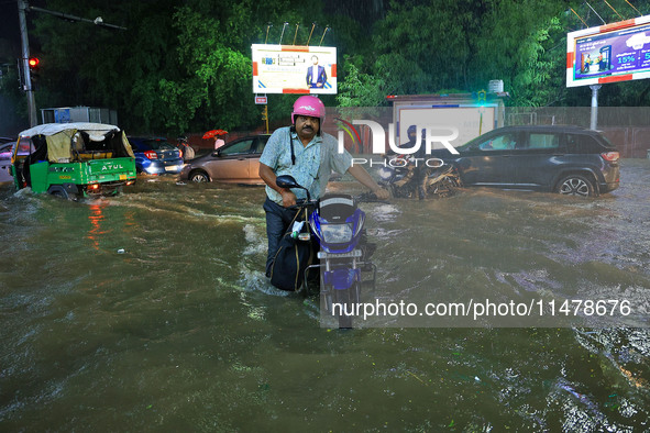 Vehicles are moving through the waterlogged road at Narayan Singh Circle following heavy monsoon rains in Jaipur, Rajasthan, India, on Wedne...