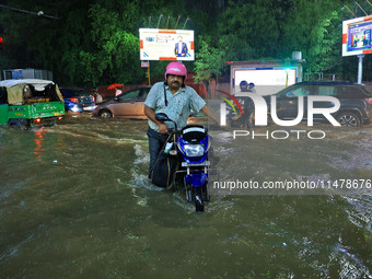 Vehicles are moving through the waterlogged road at Narayan Singh Circle following heavy monsoon rains in Jaipur, Rajasthan, India, on Wedne...