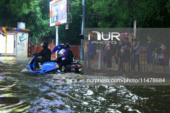 Vehicles and locals are moving through the waterlogged road at Narayan Singh Circle following heavy monsoon rains, in Jaipur, Rajasthan, Ind...